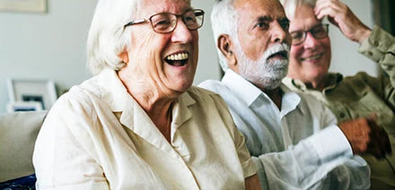 elderly people sitting together having fun watching something