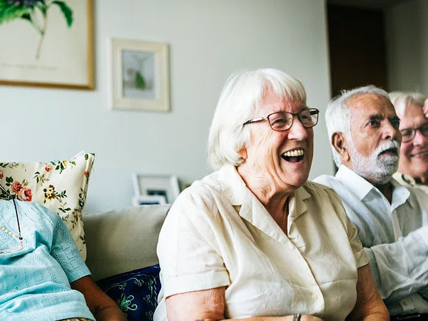 elderly people sitting together having fun watching something